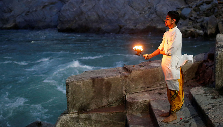 индус со светильником у воды