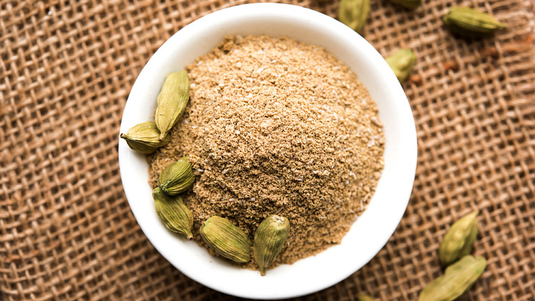 молотый кардамон, чашка молотого кардамона