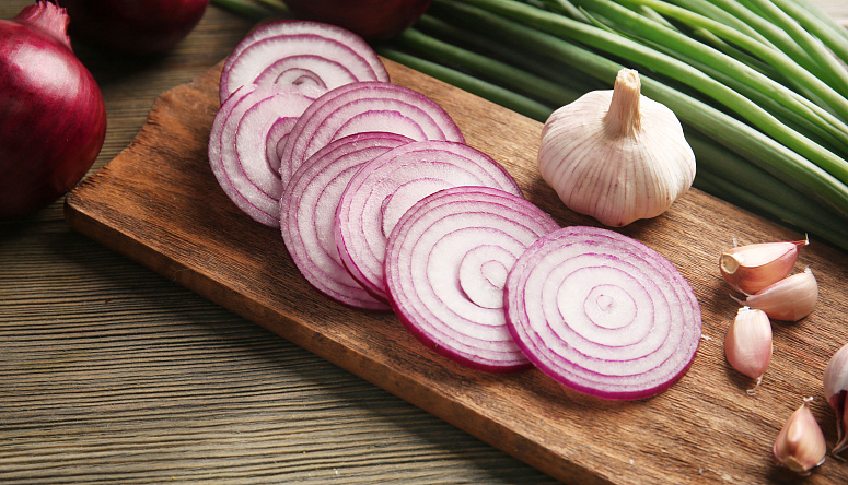 лук и чеснок на разделочной доске