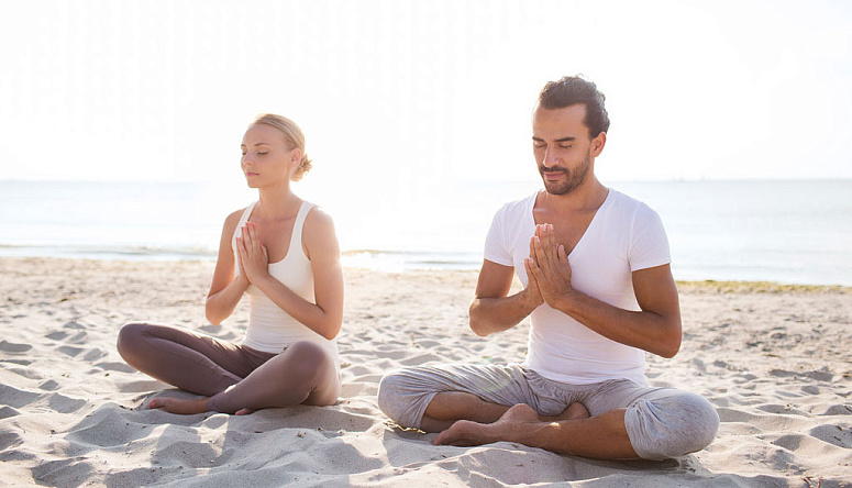 пара йогинов, девушка с парнем медитируют, йоги в намасте на берегу моря