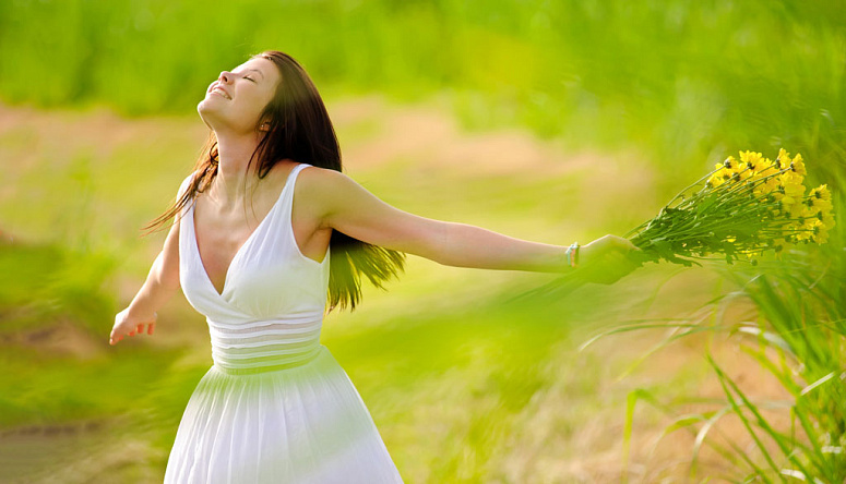 девушка с цветами радуется на природе