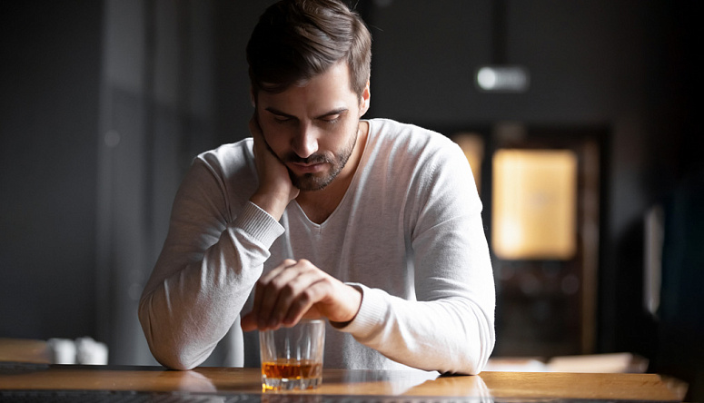 мужчина закрывает бокал рукой