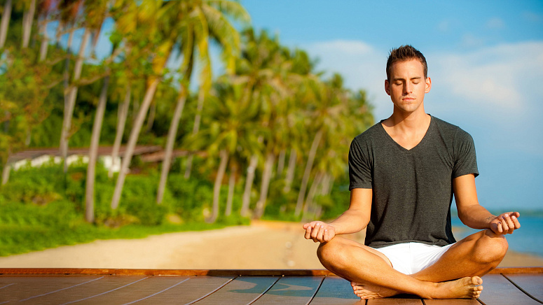 мужчина медитирует на берегу фото